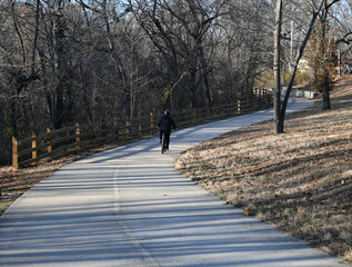 Man cycling on a paved path in the winter
