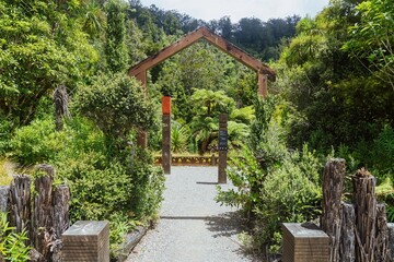 Wooden archway in a lush New Zealand garden. Nature preserve showcasing local flora and fauna....