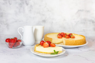 Classic sliced homemade New York cheesecake with fresh strawberries served on a marble countertop. Homemade dessert.  