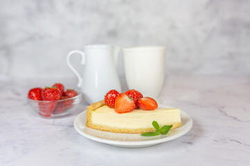 Classic sliced homemade New York cheesecake with fresh strawberries served on a marble countertop. Homemade dessert.  