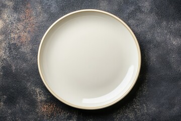 Blank round ceramic plate on dark textured concrete cutlery set for dinner