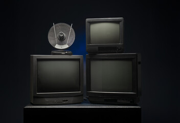 three vintage tvs with antenna on dark background for banner background