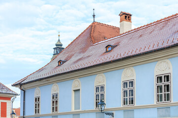 Obraz premium A blue building with a red roof and a chimney