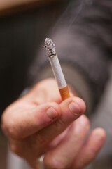 A Detailed CloseUp Image of a Hand Firmly Holding a Smoking Cigarette during an Intimate Moment