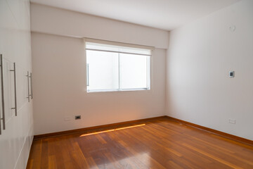 habitacion de departamento moderno con ventana y  paredes blanca, piso de melamina