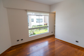 habitacion de departamento moderno con ventana y  paredes blanca, piso de melamina