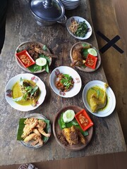 ayam goreng, ayam krispi, kudapan, sambal, acar. Indonesian dishes on a rustic wooden table. top view. Indonesian food