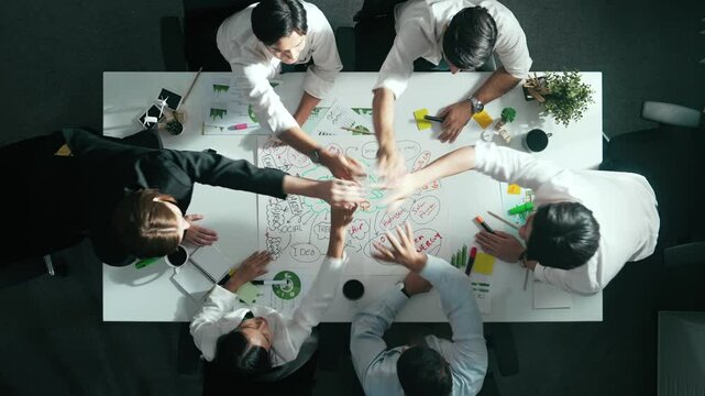 Top view of business team working together to brainstorm environmental idea by using mind map. Aerial view of smart manager talking and putting hands together or making stack of hand. Alimentation.