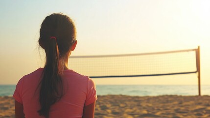 Fototapeta premium Young Girl Watching Beach Volleyball Game at Sunset by the Ocean