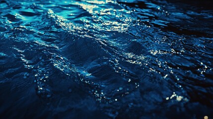 Close-up of shimmering water surface reflecting light in a dark setting.