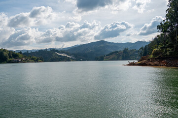 Serene lake nestled amidst rolling hills and a vibrant sky. A picturesque landscape perfect for relaxation and escape.
