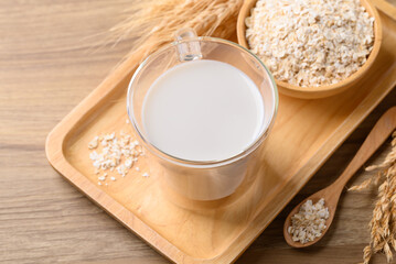 Oat milk in cup glass on wooden background, Alternative milk made from plant, non dairy