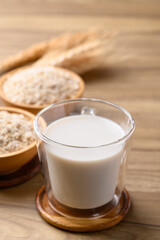 Oat milk in cup glass on wooden background, Alternative milk made from plant, non dairy