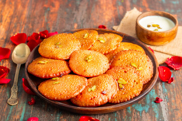 Malpua is a traditional Indian dessert made from flour, sugar, and coconut, deep-fried until crispy, then soaked in sweet syrup, often flavored with cardamom.