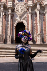 Obraz premium emblematic catrina of mexico with flowers and necklace in church with sempasuchil flowers in nature