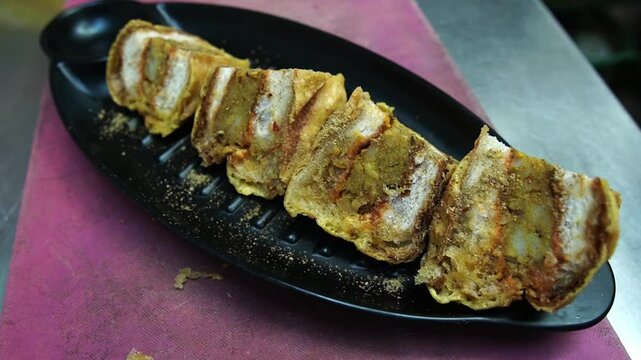 Closeup view of ulta vada paw with potato stuffings inside bun bread and shredded with cheese.