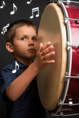 Fototapeta premium A boy playing a drum, with music notes dancing in the air
