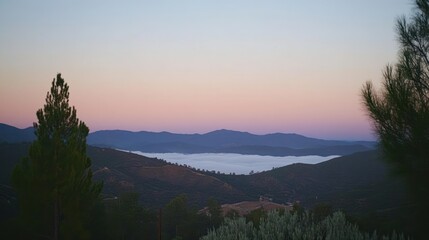 Obraz premium Serene sunrise over misty mountain valley.