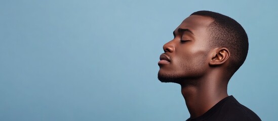 Pensive African American man reflecting on emotions with a focus on loneliness and the pursuit of happiness against a blue background