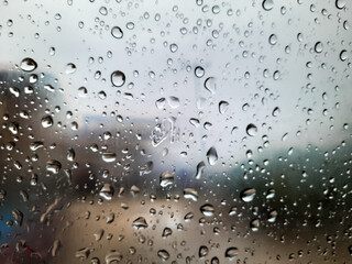 Water Droplets on Glass Window with Blurred Cityscape