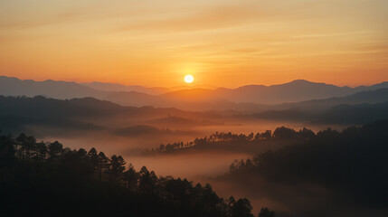 Obraz premium Sunrise over misty mountains with golden light illuminating the landscape. 