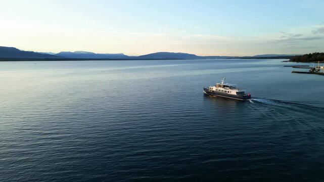 Establishing drone shot of boat sailing on Lake Geneva at sunrise in Canton of Vaud Switzerland