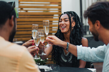 Smiling woman toasting with friends during elegant outdoor gathering