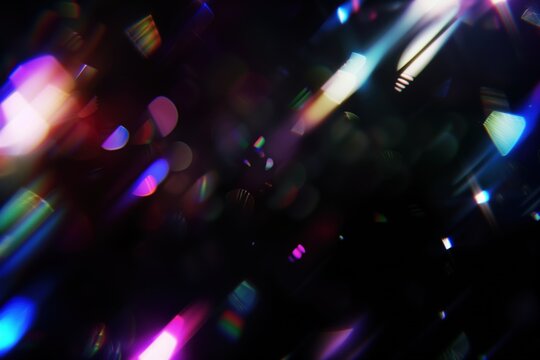 Abstract light beams in vibrant colors, bokeh and sparkling particles overlay on dark background. Rays of light, rainbow crystal glass light refraction effect.