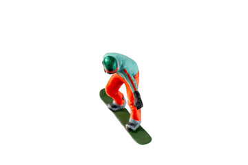 Miniature figurine depicting a snowboarder in mid-motion isolate on white background with clipping...