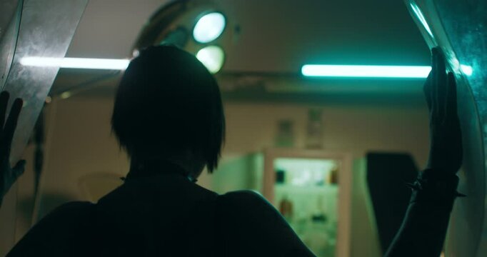 Woman walking in old clinic, crazy female person with mental disease, rearview. Dark silhouette of female maniac, tattooed lady watching old hospital with operating room, slow motion, scary movie