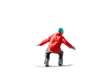 Fototapeta premium Miniature figurine depicting a snowboarder in mid-motion isolate on white background with clipping path