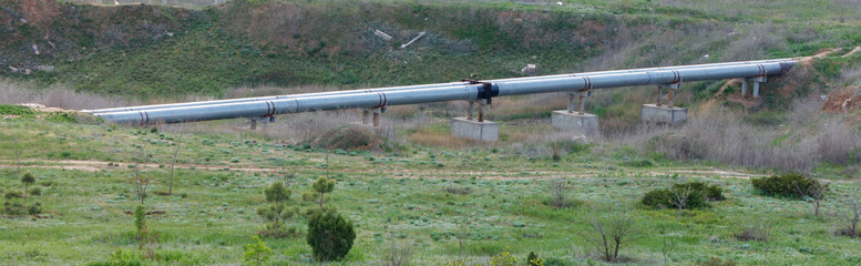 A long pipe is seen in the grassy field