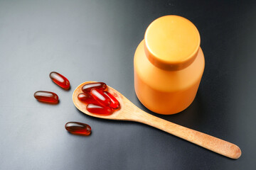 Vitamin capsules in a wooden spoon, soft gels, Fish oil capsules, omega 3, omega 9, vitamin D,...