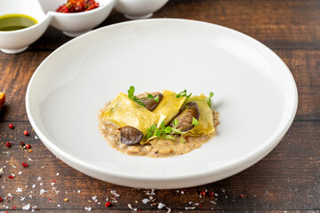 Mushroom ravioli in white porcelain plate on wooden table