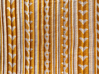 yellow silk fabric showcases a bold geometric vertical block-printed white design, blending modern and traditional aesthetics seamlessly.