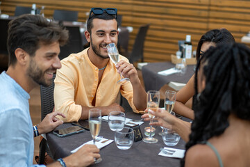 Friends enjoying champagne and socializing during an elegant outdoor dinner