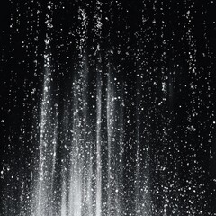 Beautiful monochrome waterfall with sparkling droplets against a dark backdrop.