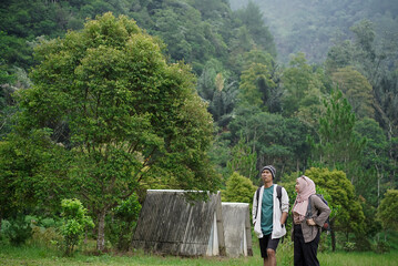 Young Indonesian female travelers wearing hijab and Indonesian male travelers enjoying a trip in nature, travel concept.