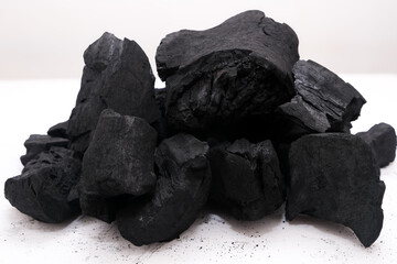 Obraz premium Pile of natural wood charcoal isolated on a white background. Hard wood charcoal.