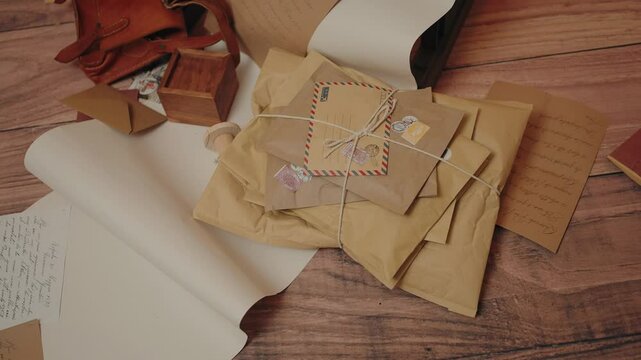 Stack of vintage parcels tied with string on a wooden surface with handwritten notes