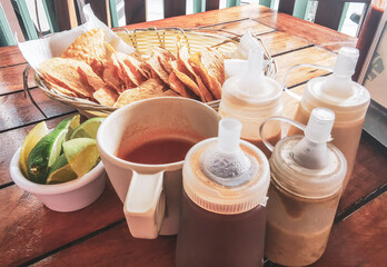 Mexican nachos in basket with sauce dispenser and limes  Mexico.