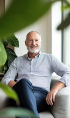 Fototapeta premium Senior Man Sitting by a Window with Potted Plants in a Modern Office