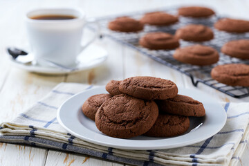 Fototapeta premium Delicious chocolate brownie cookies and coffee on a light kitchen table, selective focus.