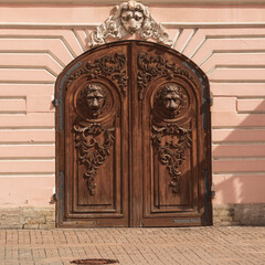 Exquisite wooden door decorated with intricate lion heads in a historic building, showing architectural elegance. High quality photo.