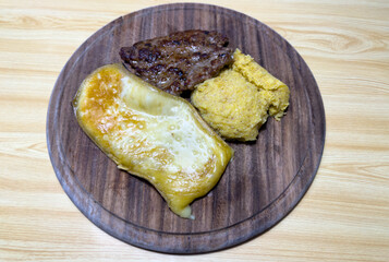 Traditional Italian mountain dish. Polenta, melted cheese and salami. Caloric and tasty dish. Plate of the Italian Alps and Dolomites