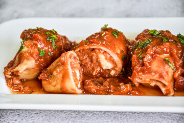 stuffed squid and tomato sauce. homemade recipe. white plate. Food
