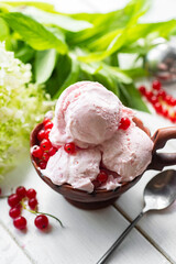 Berry ice cream with syrup in a beautiful plate on a white background. Homemade ice cream with currants. Balls of creamy ice cream in a plate. Close-up. Vertical photo
