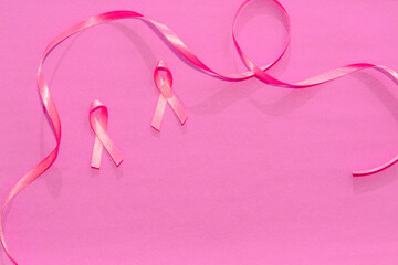 World Cancer Day. Pink ribbons representing breast cancer on a pink background with space for copying. Self-care and prevention. Strength.