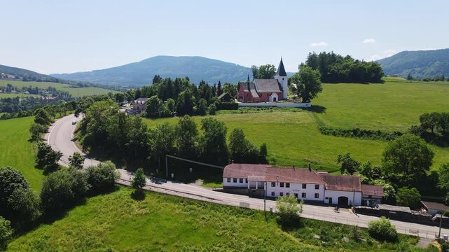 Cyclist rides uphill near Prachatice I with Church of St. Peter and Paul in view