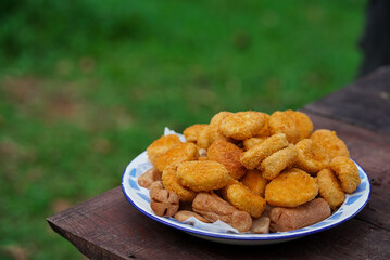 a plate full of nuggets on a picnic table, the concept of travel.